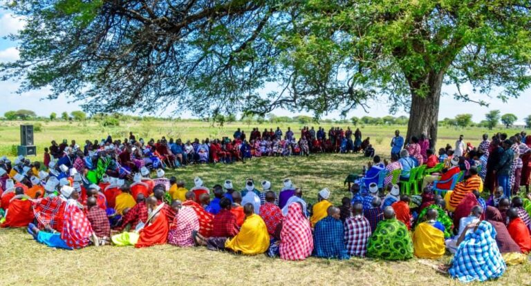 Maasai villagers gathered in a large circle under a tree
